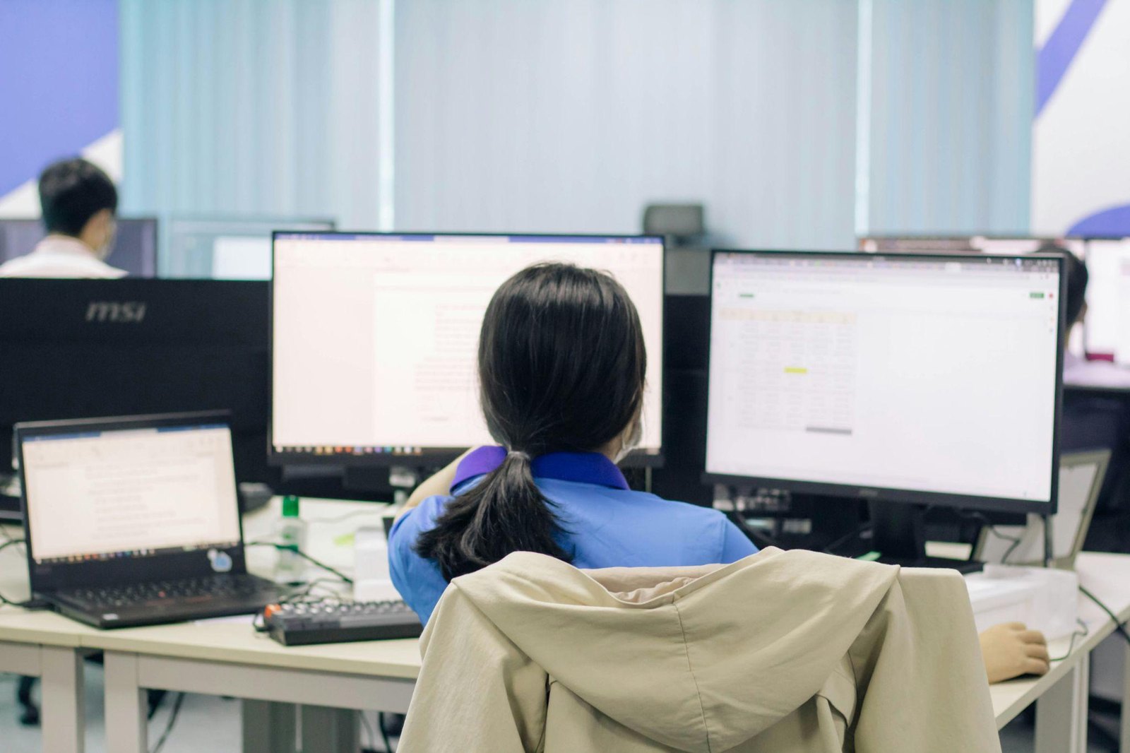 모니터 두 대로 퇴직연금 자산 배분 자료를 확인하는 직장인의 뒷모습